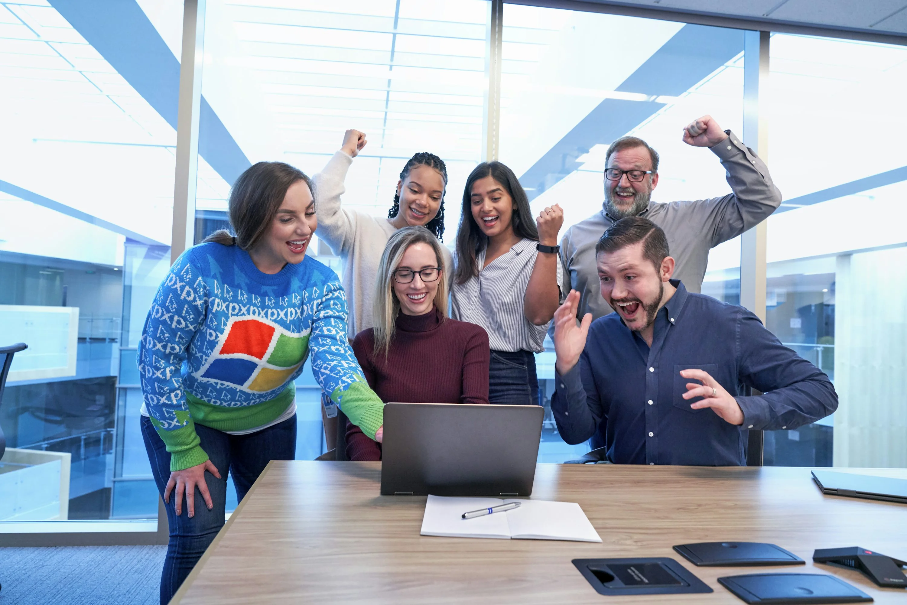 Agency team collaborating around a laptop in a bright studio