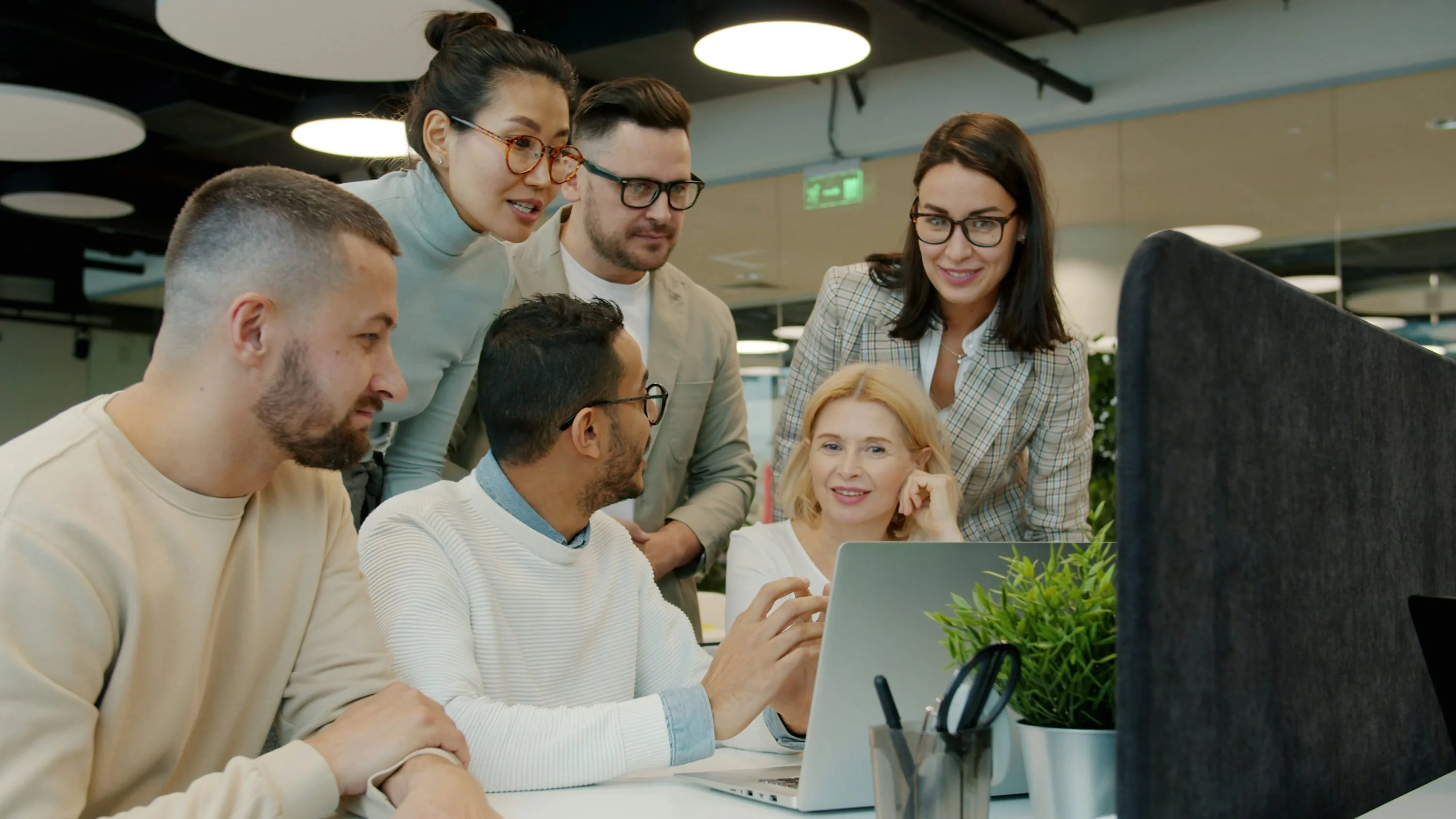 Digital agency team collaborating around a laptop